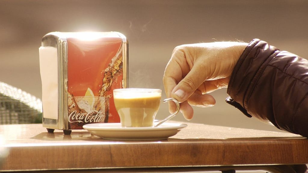Un momento di dolce far niente. Bere un caffè seduti al tavolino di un bar